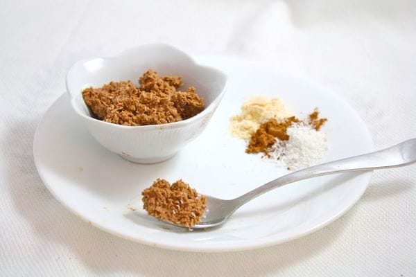 A small bowl of Instant Cocoa Bliss, a rich brown mixture with visible shredded coconut, ready to be enjoyed as a quick vegan treat.