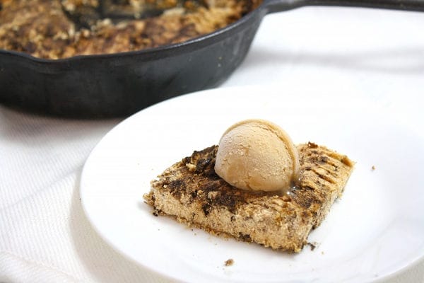 A warm, gooey vegan and gluten-free chocolate chip skillet cookie, baked in a cast-iron pan, with homemade carob chips.