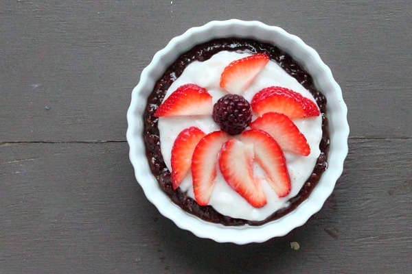A vibrant No-Bake Chocolate Cream Berry Firework Pie with a dark chocolate crust, white creamy yogurt, and a festive arrangement of sliced red strawberries and dark berries on top.