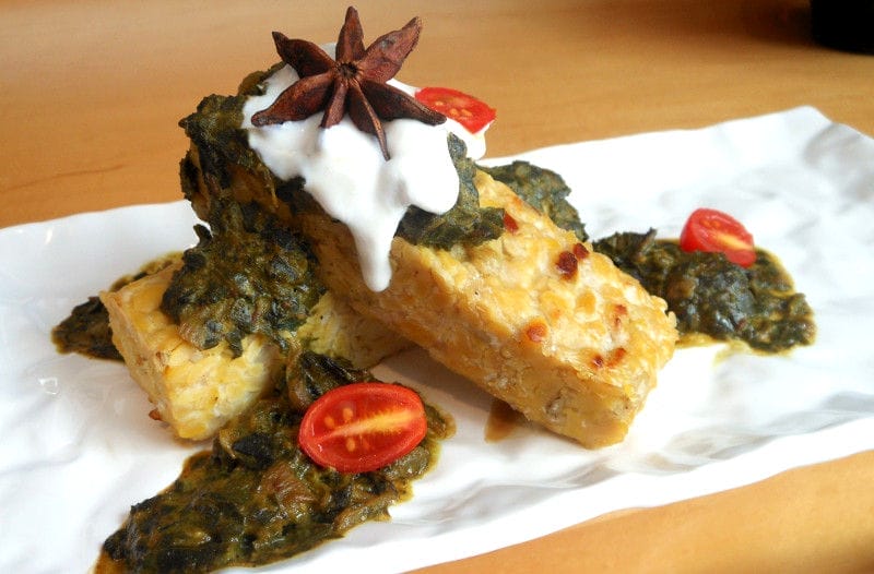 A vibrant bowl of creamy Indian Cashew Swiss Chard, served over fluffy Basmati rice and garnished with fresh cilantro.