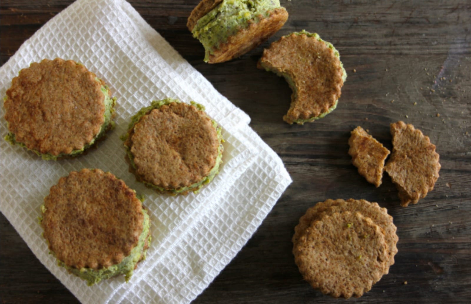 A stack of two Espresso Biscuit and Pistachio Ice Cream Sandwiches, showing the dark espresso biscuits and vibrant green pistachio ice cream filling.