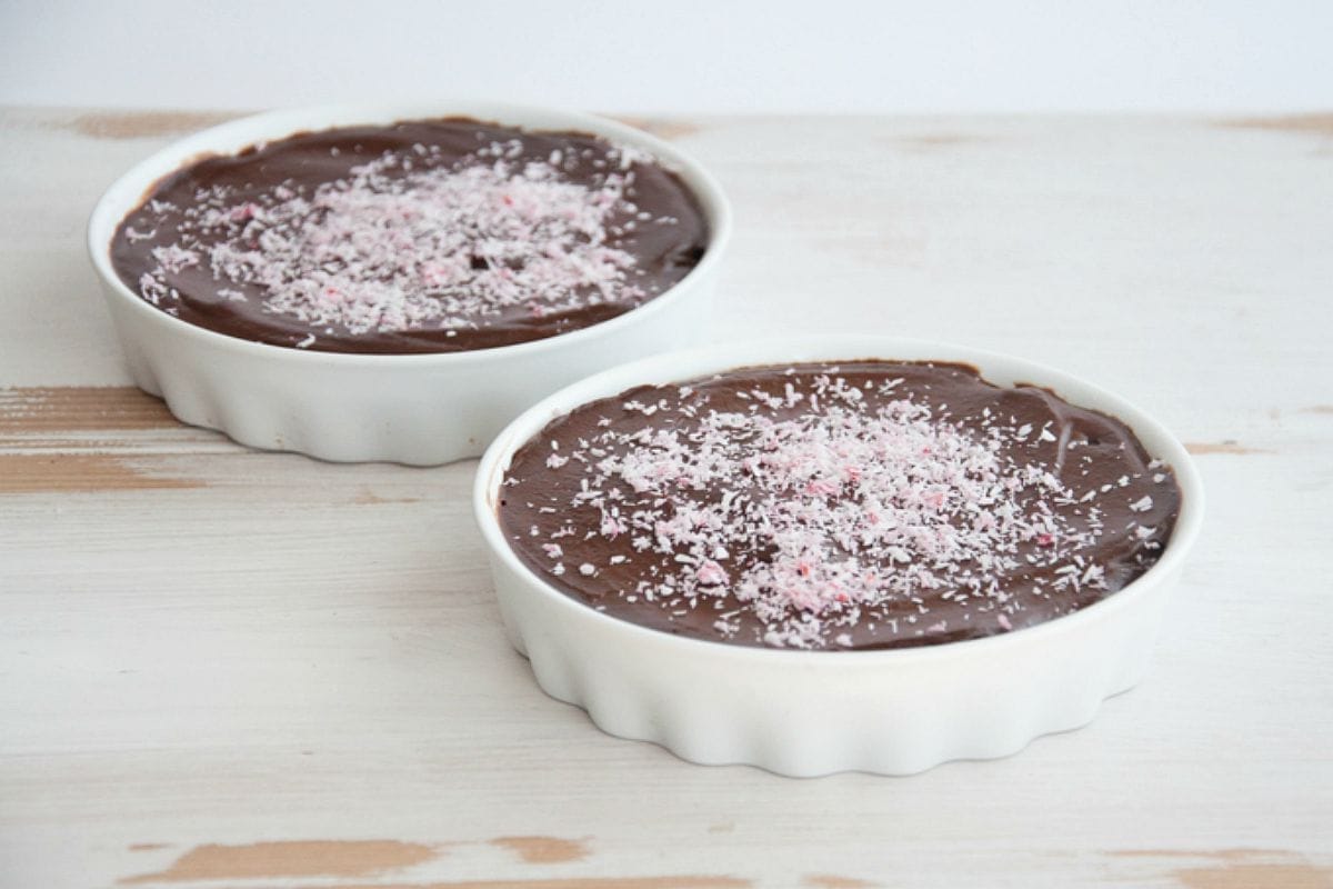 A single cocoa avocado tartlet, topped with vibrant pink coconut sprinkles, presented on a white plate.