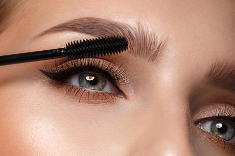 Woman putting on mascara