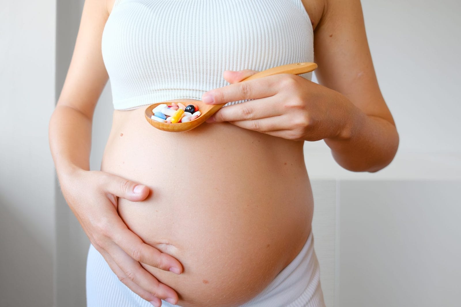 vegan prenatal vitamins with a glass of water on a kitchen counter